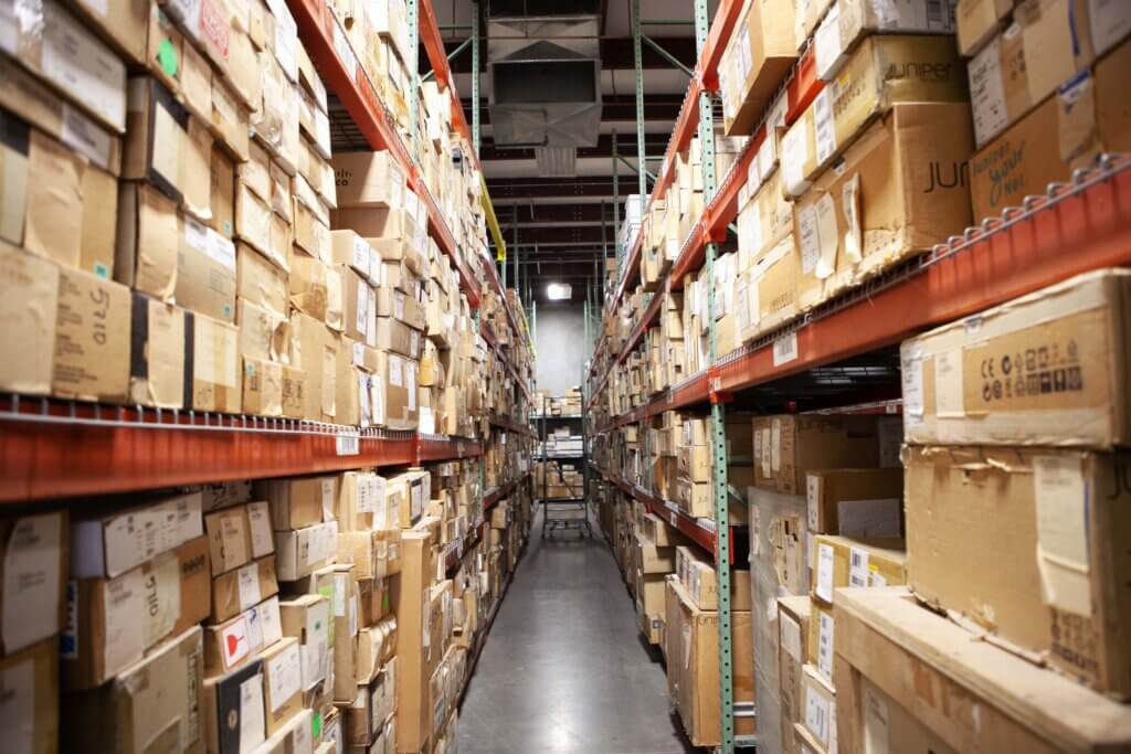 A row of 2 shelves that are stacked with packages in one of the Xcel Delivery distribution centers
